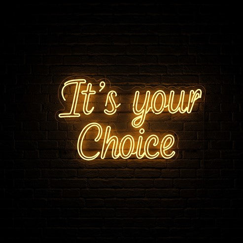 Bold yellow neon sign reading 'It's Your Choice' glowing against a dark brick wall, perfect for adding a personalised and stylish touch to your space.